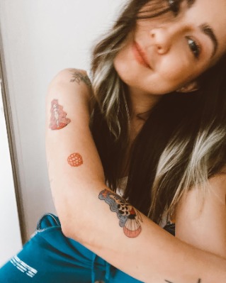 Gia Olimp flaunting her tattoos on her arms and shoulder. 